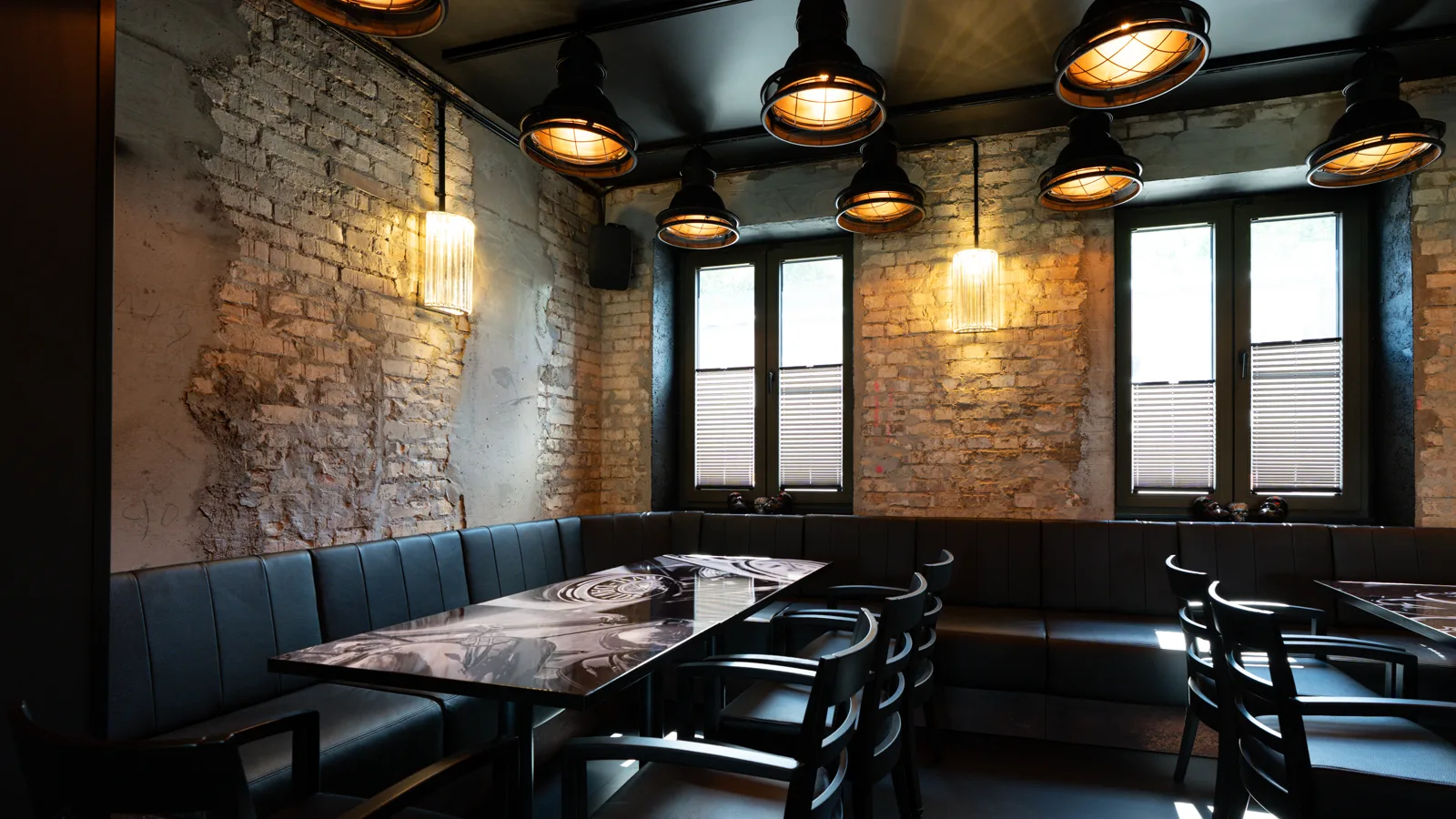 The dining room of the Silberwolf Biker Bar with brick walls, leather benches and industrial lamps