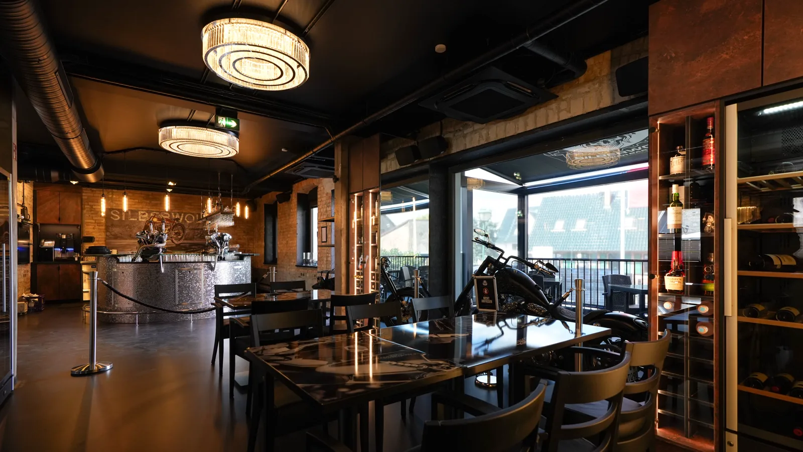 The restaurant of the Silberwolf Biker Bar with wine cabinet, custom bike and a view of the round bar