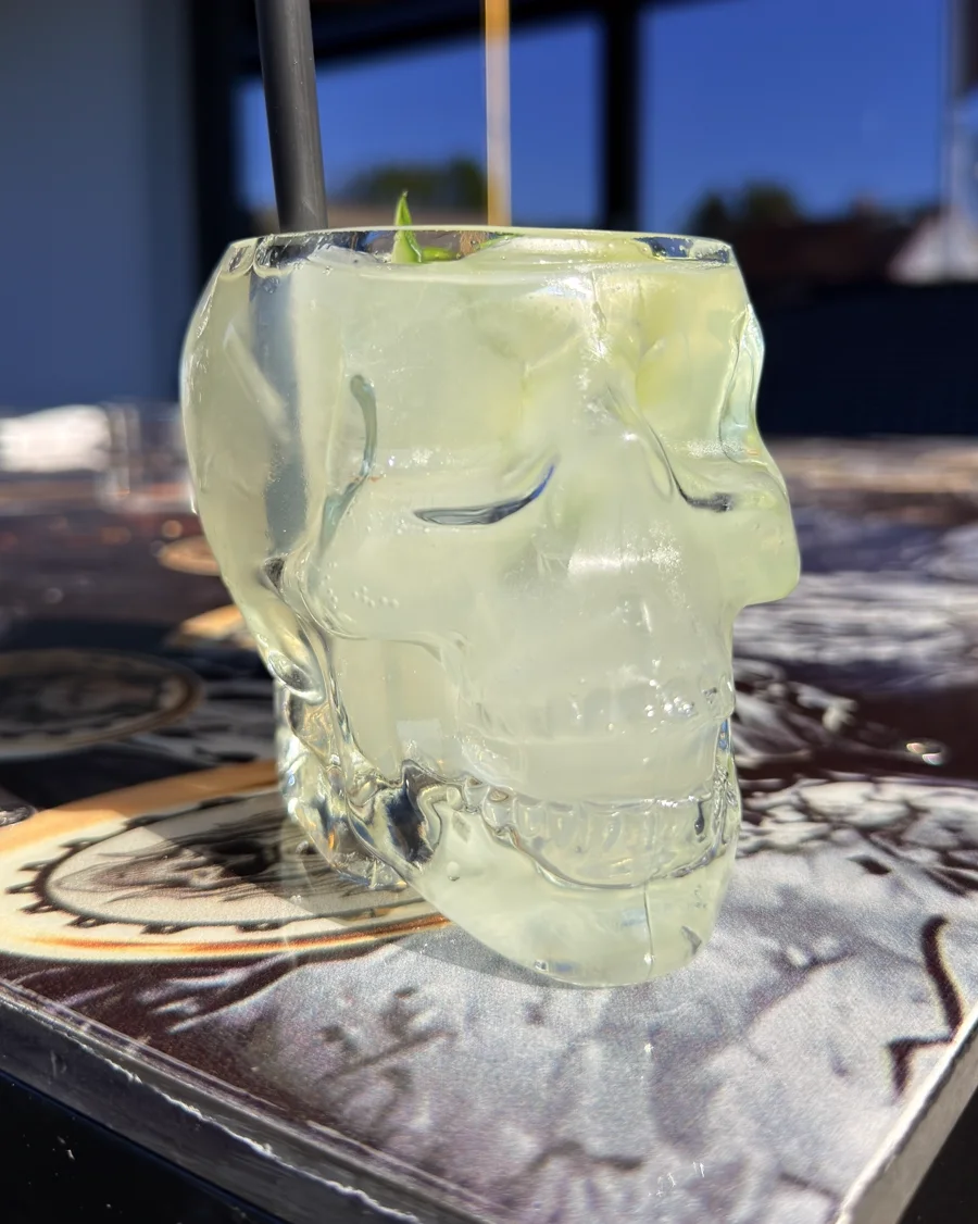 Signature-Drink im Totenkopf-Glas der Silberwolf Biker Bar: Kristallglas in Schädelform, gefüllt mit Eis, Limette und Gurke