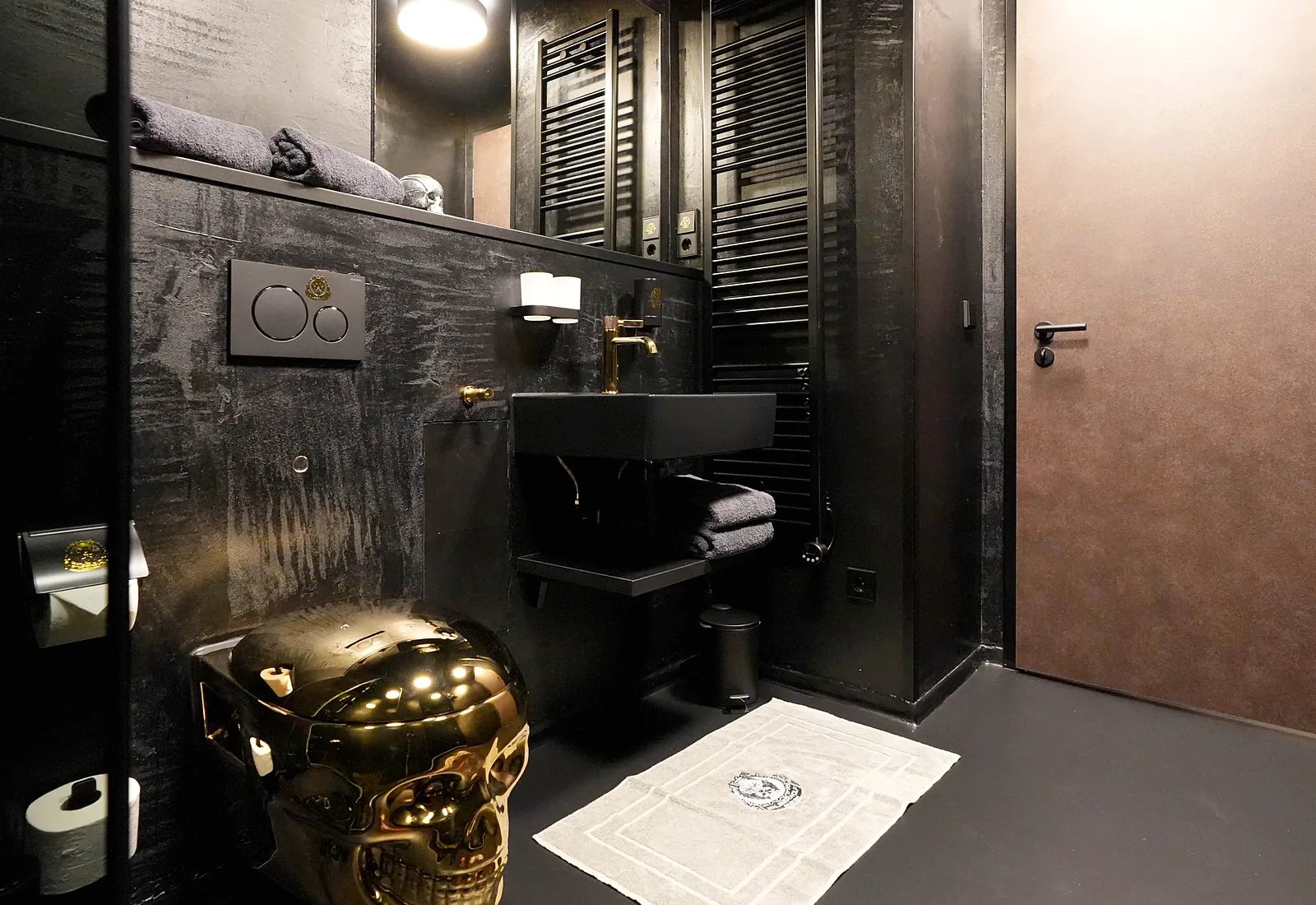 Black bathroom in the Fat Boy room with a golden skull toilet