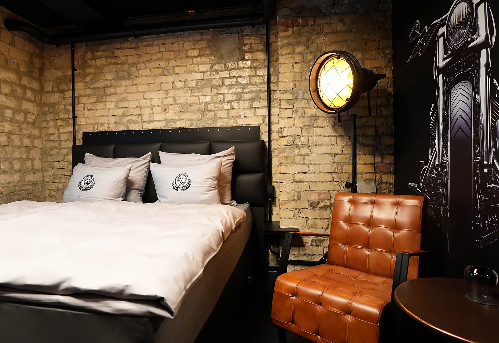 Sportster room: bed against a brick wall, next to it a large motorcycle mural