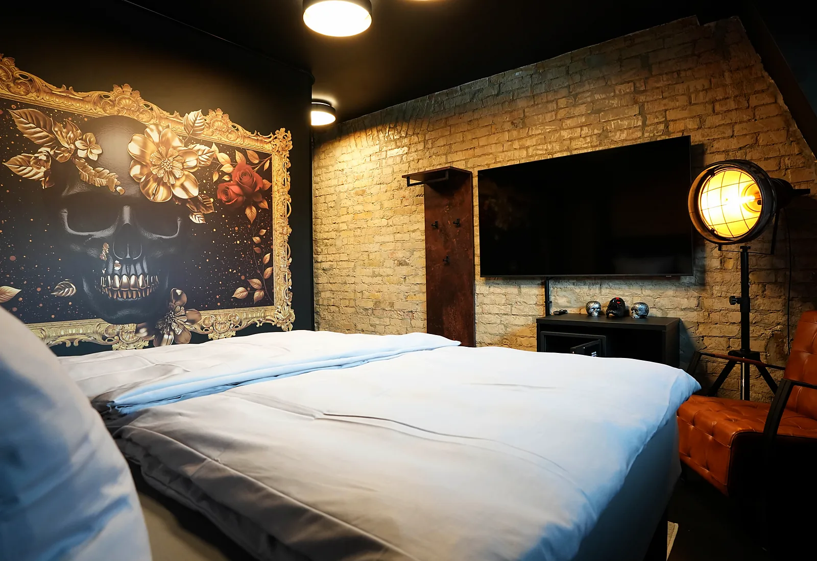 Street Bob room: bed beneath the skull mural in a gold frame