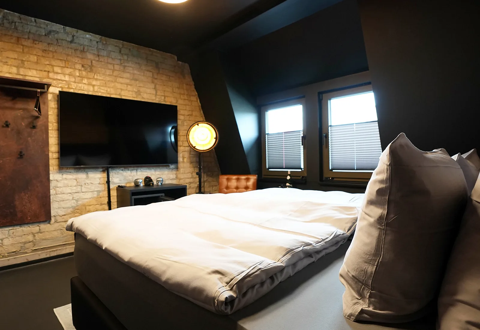 Zimmer Street Bob: Boxspringbett, Fernseher an der Backsteinwand und zwei Fenster