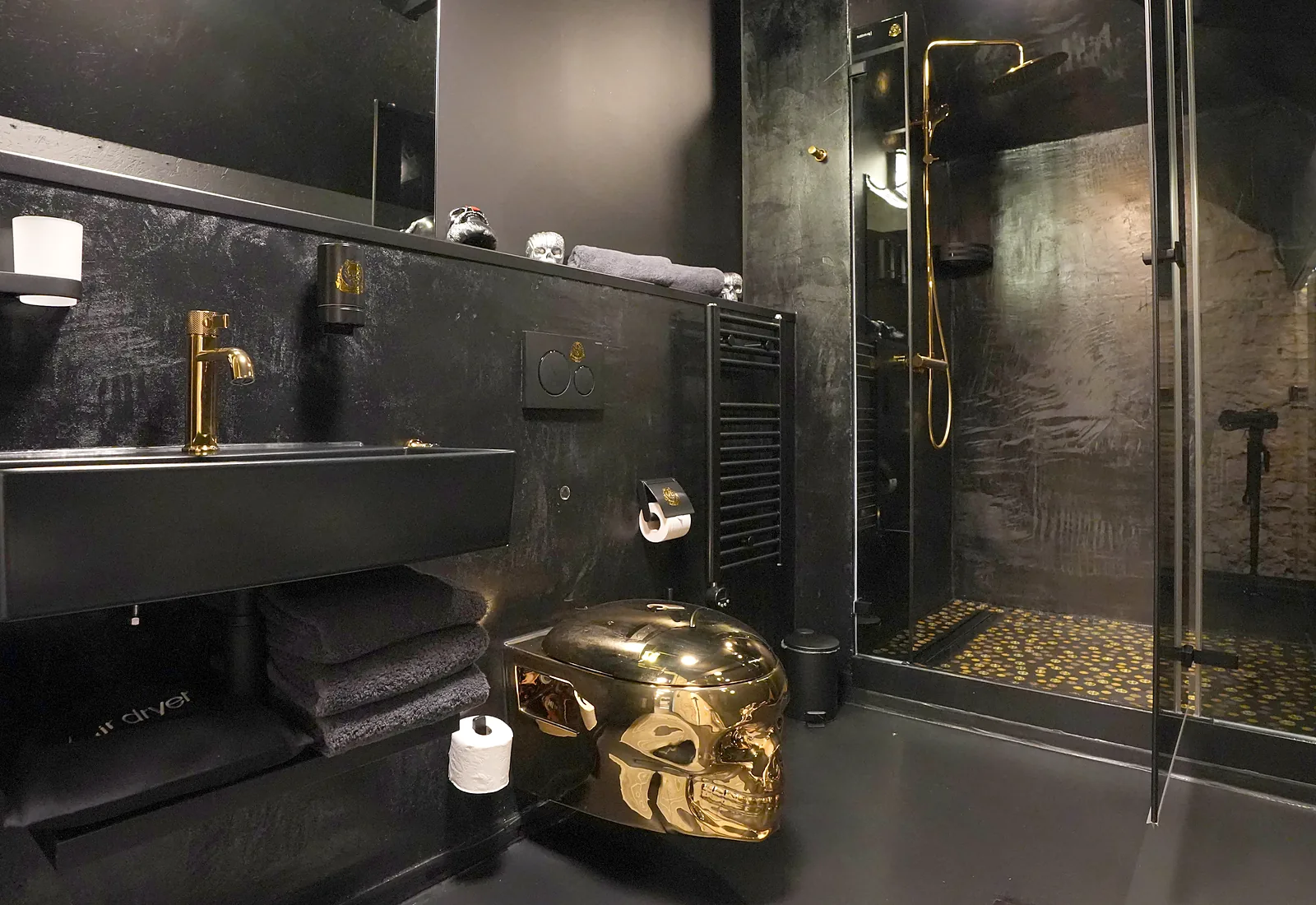 Schwarzes Bad der Suite mit goldenem Totenkopf-WC und goldenen Armaturen