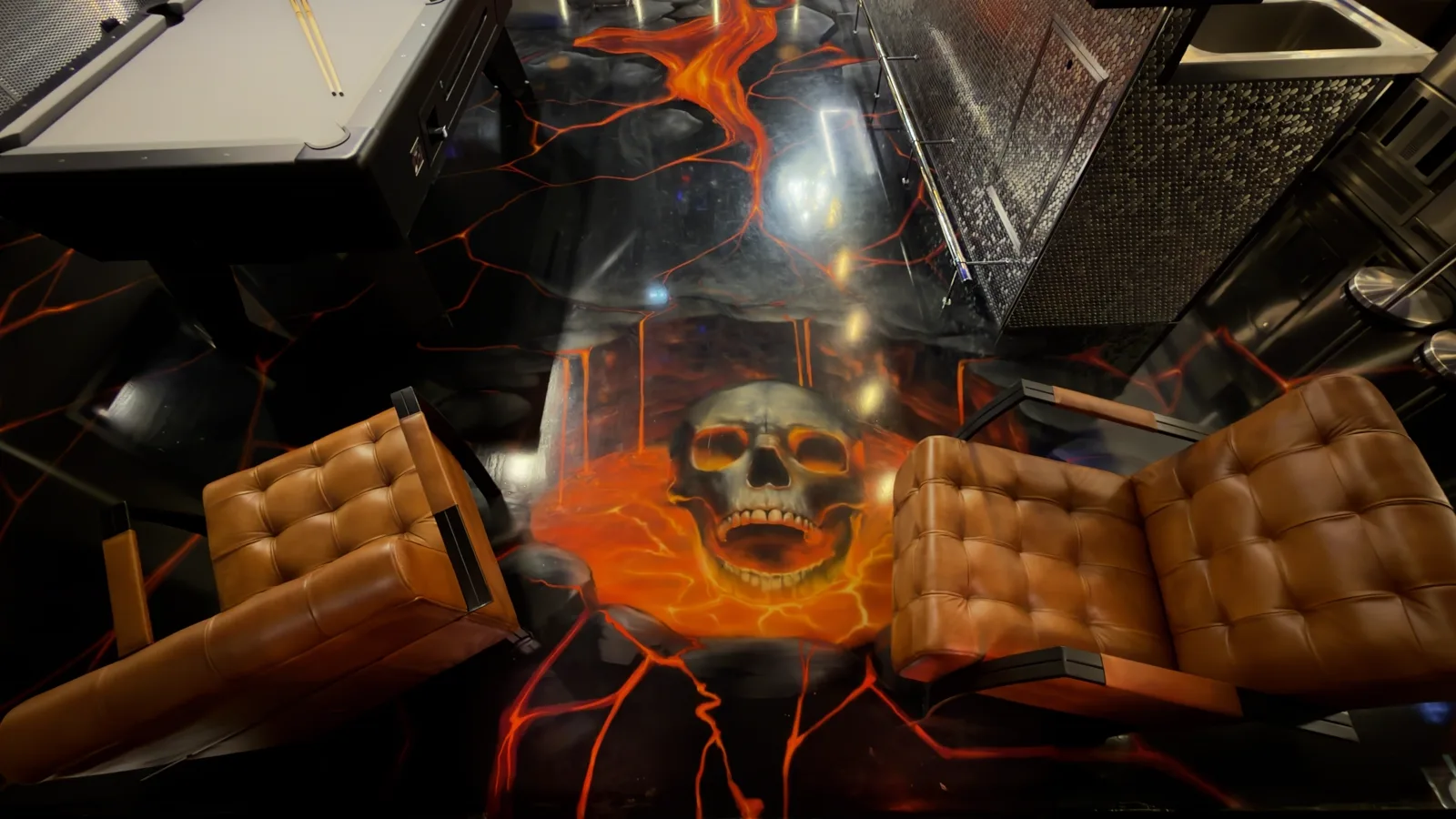 Skull in the barn's lava floor between two leather chairs, seen from above