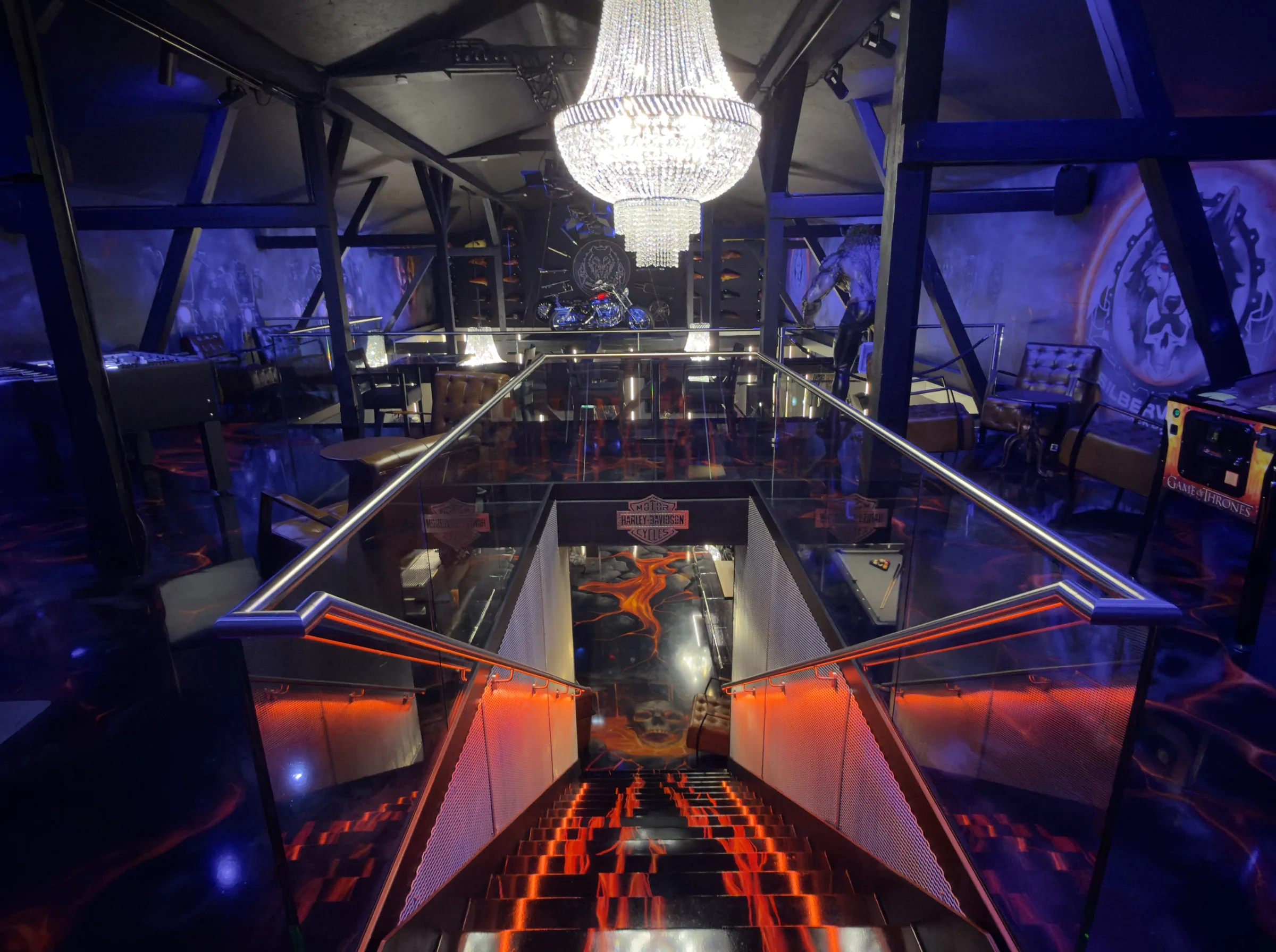 Die Treppe zur Empore, beleuchtet wie glühende Lava, darüber ein Kronleuchter